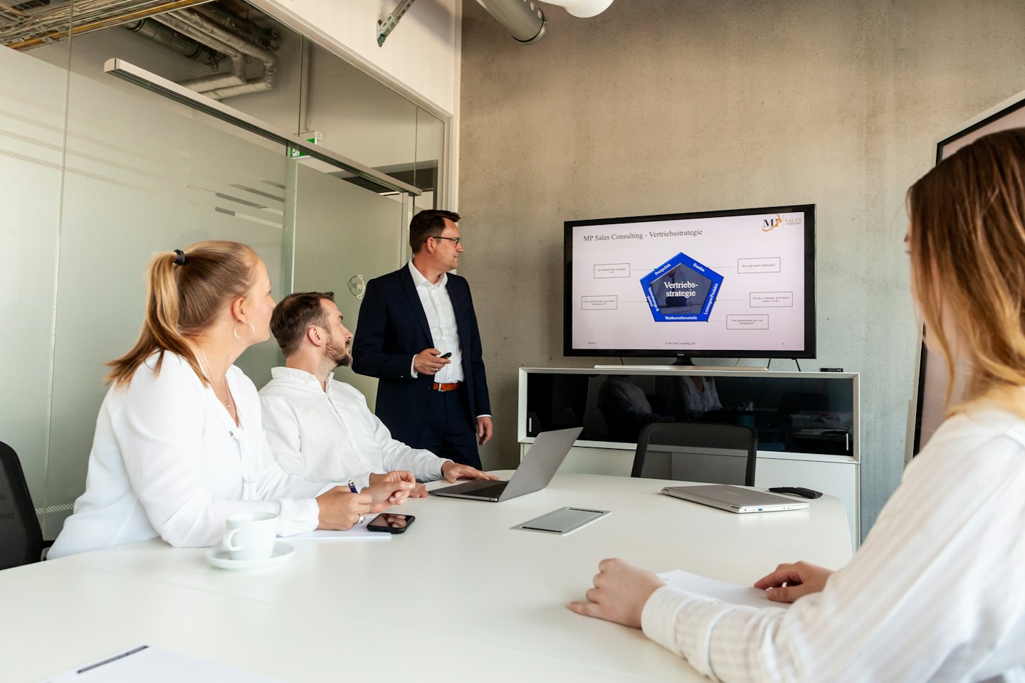 Seorang pria mempresentasikan strategi bisnis kepada rekan-rekannya di kantor modern.